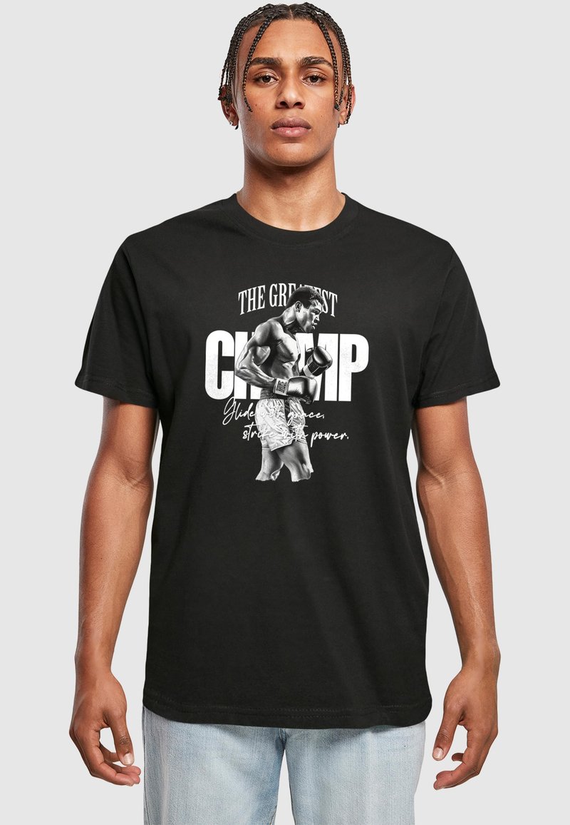Black cotton t-shirt featuring a large graphic of a boxer with text: "The Greatest CHAMP" in white and cursive accents. Classic crew neck design.