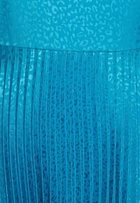 Robe plissée bleu sarcelle avec un motif léopard texturé. Le tissu a un éclat, avec des plis verticaux et des détails de design bleus contrastants.