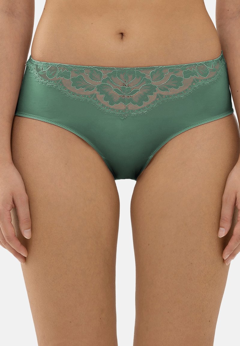 Groene satijnen slip met een bloemenkant trim langs de tailleband. Het ontwerp heeft een gladde textuur en een gemiddelde taillehoogte.
