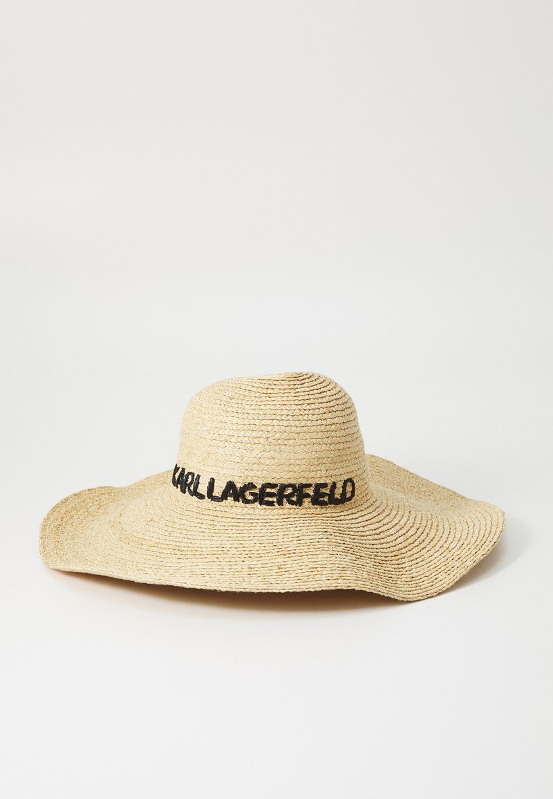 Chapeau de paille à large bord avec texte noir « KARL LAGERFELD » brodé autour de la base de la calotte sur un fond uni.