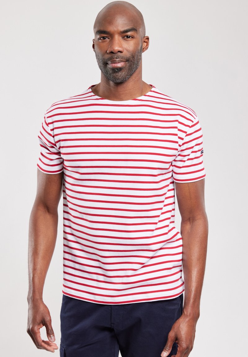 Camiseta de manga corta a rayas rojas y blancas, hecha de algodón suave, con un escote redondo y un pequeño logo en la manga.