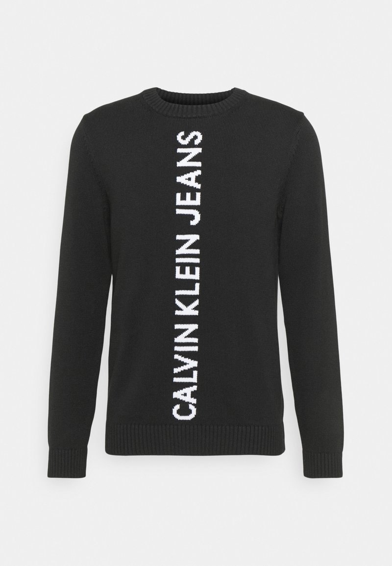 Pull en maille noire à manches longues avec un texte vertical blanc "Calvin Klein Jeans" au centre devant.