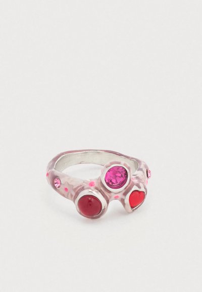 Bague avec une monture en argent ornée de trois pierres précieuses colorées : rose, rouge et rose foncé. Le design comporte des points en relief sur la monture.