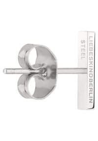 Silberner Stahlstecker mit einem geschwungenen floralen Design, geradem Stift und rechteckiger Rückseite, die mit dem Markennamen graviert ist.