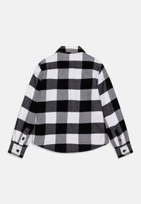 Črno-bela karirana srajca z dolgimi rokavi, ovratnikom in gumbastimi manšeti, narejena iz mehkega blaga s teksturiranim vzorcem.