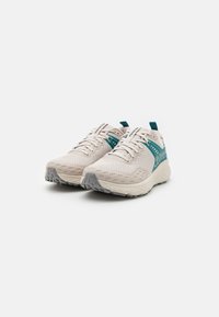 Light beige athletic shoes with mesh upper, teal accents, and gray outsole. Features thin laces and padded tongue for comfort.