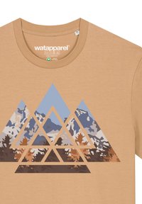 Beige Baumwoll-T-Shirt mit einem geometrischen Bergdesign in Blau, Weiß und Braun, das aus dreieckigen Formen und geschichteten Texturen besteht.