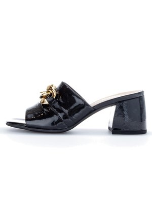Mule en cuir verni noir à bout ouvert, talon bloc et chaîne décorative dorée sur la bride supérieure.