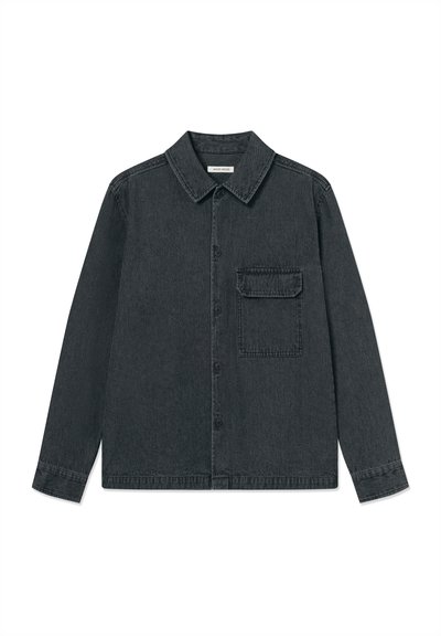 Crna teksas košulja jakna s okruglim ovratnikom, dugim rukavima, zatvaranjem na prednje gumbe i jednim džepom na prsima. Prisutan je vertikalni teksturni detalj.