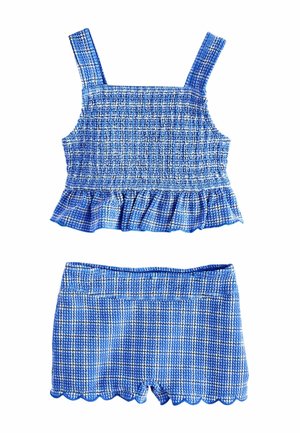 Modrý kockovaný crop top s textúrou, volánovým lemom a krátke šortky s vlnkovaným okrajom, bez rukávov so širokými ramienkami.