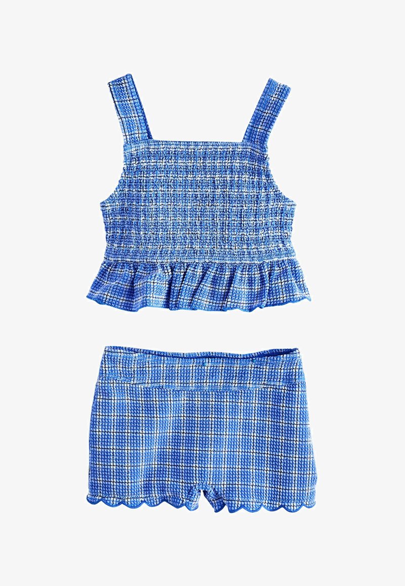 Blue checkered textured crop top with ruffle hem and matching scalloped edge shorts, sleeveless with wide straps.