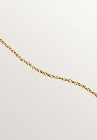 Collar de cadena de oro con eslabones ovalados interconectados, textura suave y acabado pulido, sobre un fondo claro.