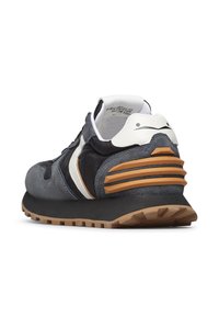 Sneaker grigio scuro e nero con accenti bianchi, suola in gomma e supporto per il tallone testurizzato, mostrato dal lato posteriore sinistro su uno sfondo bianco.