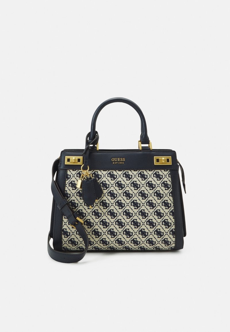 Sac à main Guess noir et beige avec motif monogramme, poignées supérieures, bandoulière détachable et détails en métal doré.