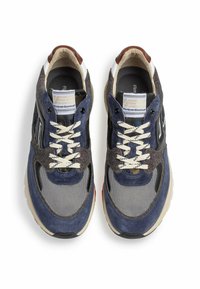 Laikanssin ja harmaan mokkanahkaiset tennarit, joissa on verkkomateriaali, kermanväriset nauhat ja kumipohja. Mukana on vaaleanruskea nahkakoriste kantapäässä sekä bränditunnus.