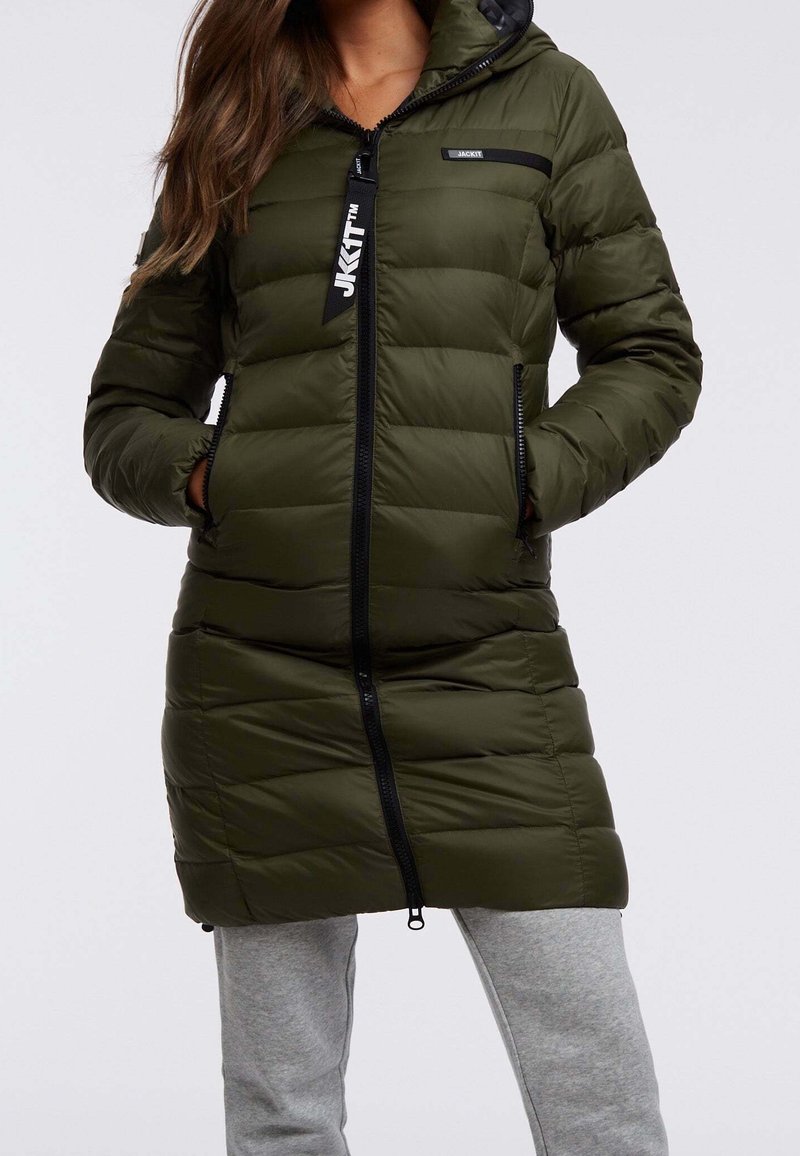 Manteau rembourré vert olive avec capuche, présentant des coutures horizontales, une fermeture éclair à l'avant et des poches zippées sur les côtés. Détails d'accents noirs visibles.