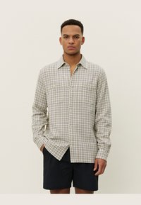 Lichtgewicht, beige geruite shirt met een button-down kraag en lange mouwen. Heeft twee borstzakken en een ontspannen pasvorm.