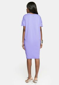 Fioletowa bawełniana sukienka w t-shircie z krótkimi rękawami i prostym krojem, z małym logo z tyłu i gładką fakturą.