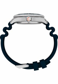 Montre en acier inoxydable argenté avec un cadran rond, une lunette texturée et un bracelet en silicone bleu foncé avec un design ondulé et une fermeture à boucle.
