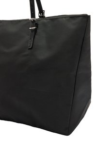 Czarna torebka na ramię wykonana z teksturowanej tkaniny. Posiada dwa solidne uchwyty oraz prostokątny kształt z zamknięciem na zamek. Minimalistyczny design.