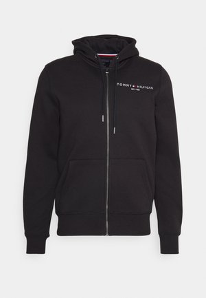 Sudadera con cremallera negra hecha de una mezcla de algodón. Cuenta con capucha ajustable, bolsillos frontales y un logo bordado en el pecho.