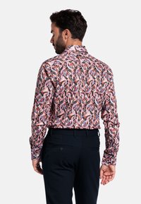 Langemouwen shirt met een kleurrijk bloemenpatroon in roze, blauw en zwart. Heeft een klassieke kraag en een getailleerd ontwerp met knoopdetails.