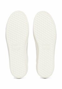 Semelles en caoutchouc blanches avec un motif en diamant texturé et un logo de marque en relief. Forme arrondie et bords lisses.