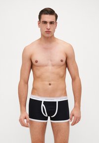 Svarta boxertrosor med vita detaljer, med en elastisk midja märkt "DSQUARED2" och en figurnära design. Mjuk tyg.
