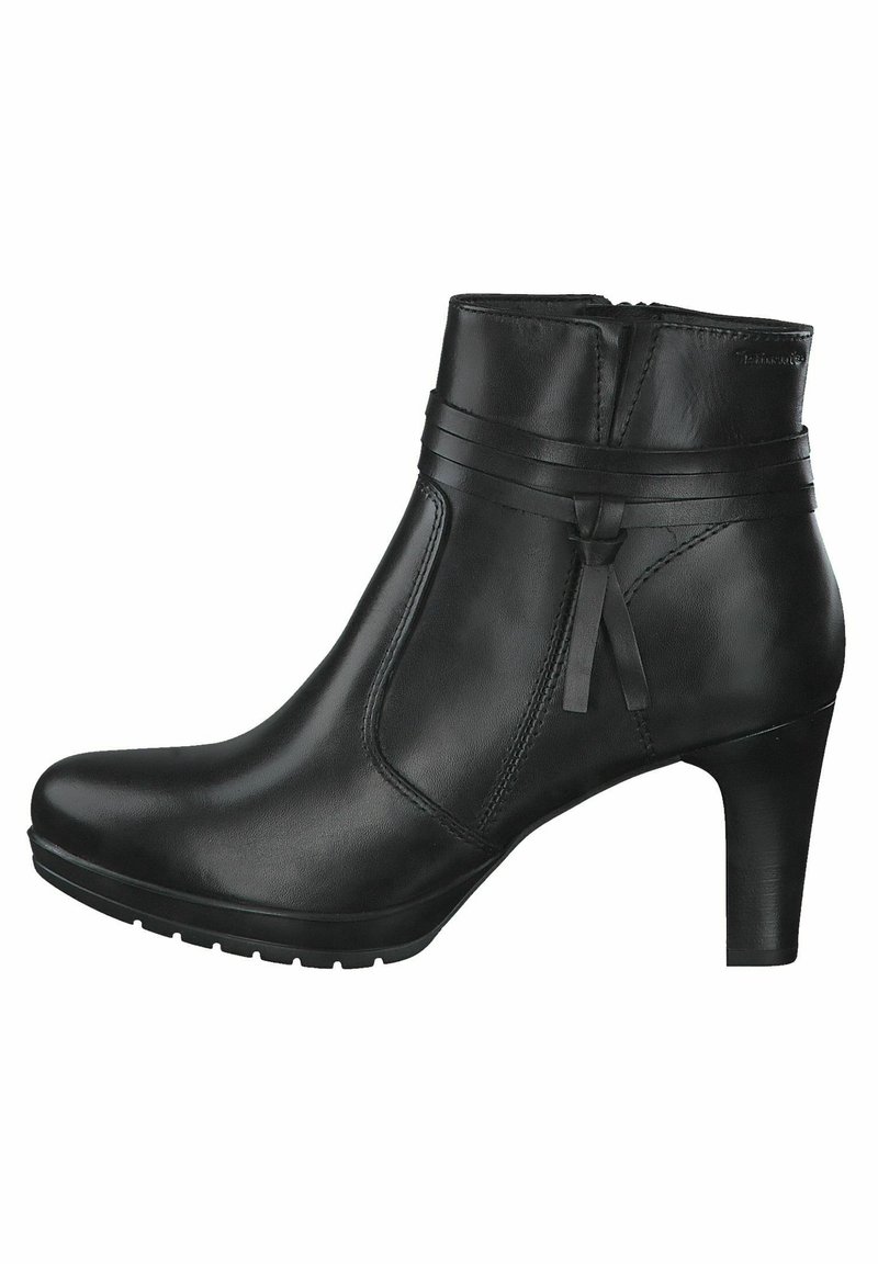 Bottine en cuir noir avec un bout arrondi, un talon haut, des sangles décoratives et une texture lisse. Fermeture éclair sur le côté.