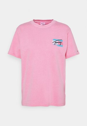 Pink short-sleeve crew neck t-shirt with small blue and red graphic and black "Tommy" text on the left chest.