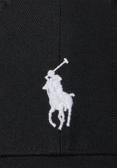 Casquette de baseball noire avec logo de joueur de polo blanc brodé, dotée d'une couronne structurée et d'une visière plate, fabriquée en tissu tissé.