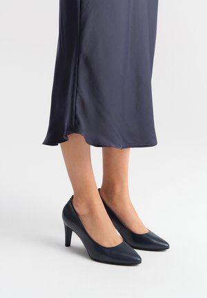 Pumps neri in pelle con tacco alto e punta affusolata, texture liscia e un ritaglio modesto sui lati. Adatte per abbigliamento formale.