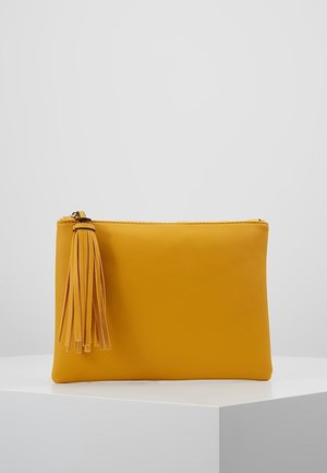 Pochette con zip in pelle gialla, dalla superficie texture e dettaglio con lunga nappina piatta, caratterizzata da un design liscio e minimalista.