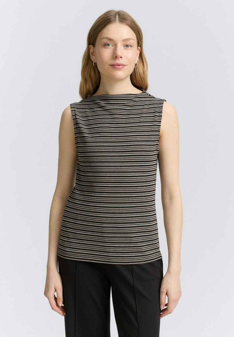 Zwart-wit gestreept mouwloos topje met een hoge hals, gemaakt van textuurstof, gecombineerd met een goed zittende zwarte broek.