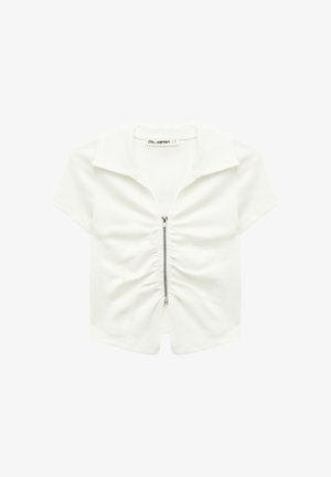 Top blanco de manga corta y corte corto con cuello y cremallera frontal plateada, con detalle de tela fruncida a lo largo de la línea de la cremallera.