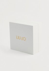Λευκό υφασματοποιημένο ορθογώνιο κουτί με χρυσό λογότυπο "LIU·JO" κεντραρισμένο εμπρός, τοποθετημένο σε μια απλή λευκή επιφάνεια.