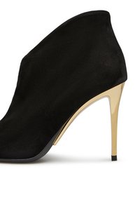 Stivale alla caviglia in pelle scamosciata nera con un alto tacco metallico dorato. Il design presenta una silhouette affusolata e una consistenza liscia.