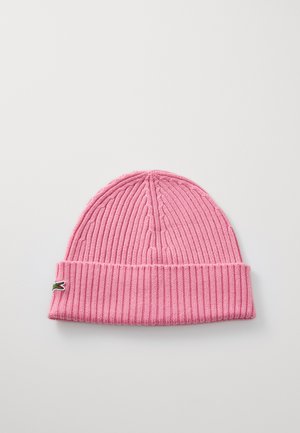 Gorro de punto rosa con textura de canalé y puño doblado, que presenta un pequeño logo de cocodrilo verde en el lado.