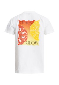 White cotton t-shirt featuring a graphic print of a sliced orange and lemon, with the text "CITRUS GLOW" against an orange gradient background.