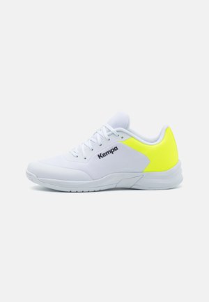White sports shoe with a mesh upper and padded collar. Notable neon yellow accent on the heel and black logo on the side.