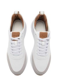 Weiße Sneakers mit braunen Akzenten, ausgestattet mit einem glatten Obermaterial, runder Zehenpartie, flachen Schnürsenkeln und einer strukturierten Sohle. Minimalistisches Design.