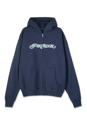 Navy blue zip-up hoodie made of cotton blend fabric. Features a front kangaroo pocket and "PEGADOR" logo in light blue across the chest.