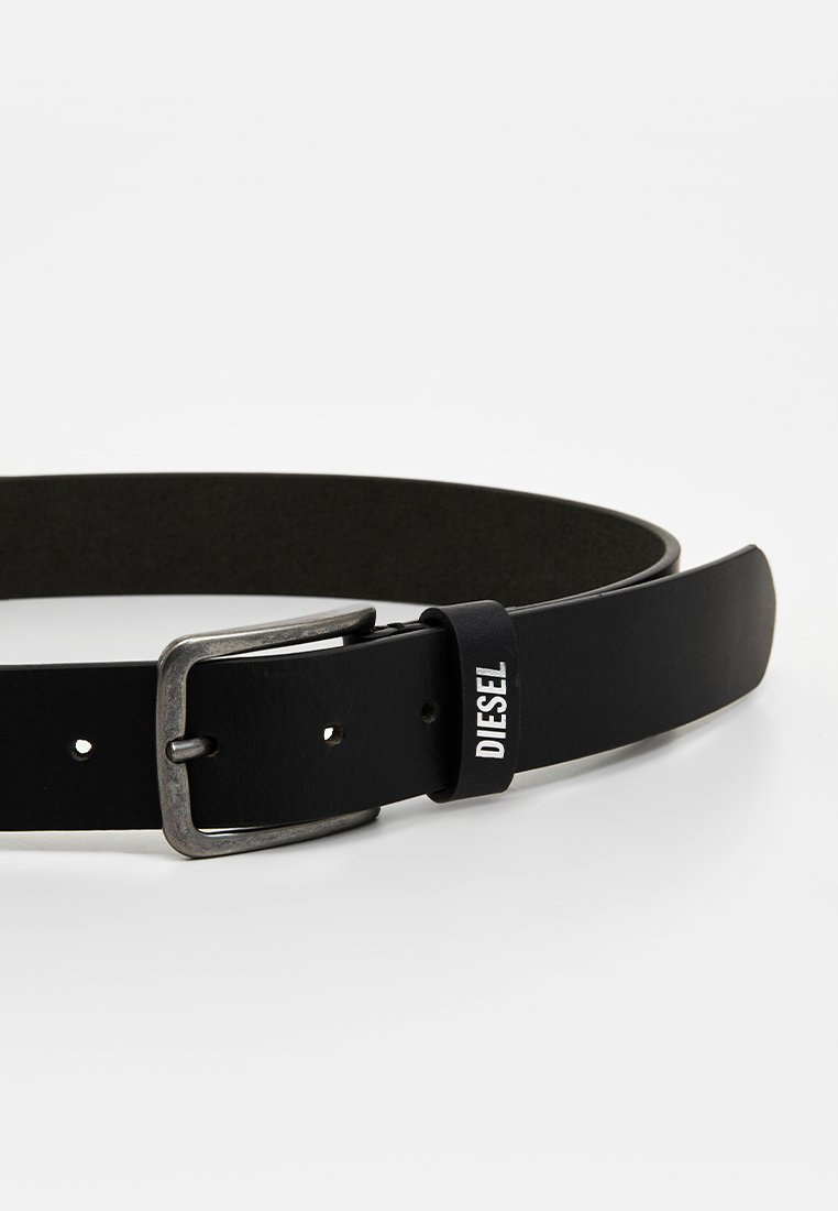 Schwarzer Leder-Gürtel mit mattem Finish, silberfarbener Metallschnalle und einem kleinen weißen Logotag. Verfügt über fünf Löcher und ein glattes Kanten-Design.