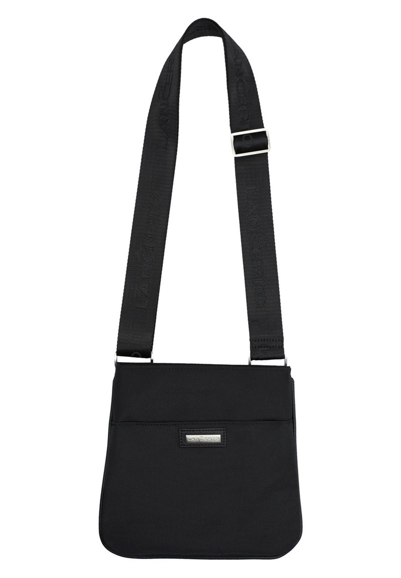 Czarna torebka na ramię o płaskim designie, z regulowanym paskiem, srebrną naszywką z logo i przednią kieszenią. Gładka faktura.