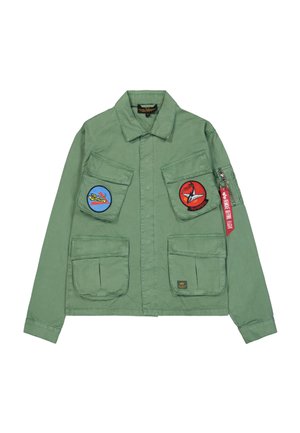 Chaqueta verde estilo militar con dos grandes bolsillos frontales con parches azules y rojos, bolsillo con cremallera en la manga izquierda y una etiqueta de tela.
