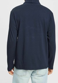 Mörkblå långärmad skjorta med hög krage, mjuk textur och normal passform. Baksidan har minimal sömnad och inga grafiska tryck.