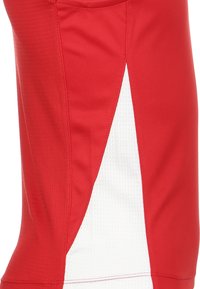 Rotes Sportshirt mit strukturierter Stoffoberfläche, seitlichem weißen Akzentpanel zur Kontrastverstärkung und kurzen Ärmeln.