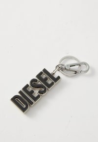 Nøkkelring med svarte "DIESEL" bokstaver med glossy overflate, festet til en metallring og klips for enkel festing til vesker eller nøkler.