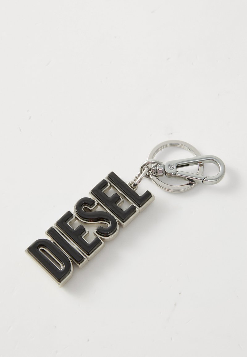 Nøkkelring med svarte "DIESEL" bokstaver med glossy overflate, festet til en metallring og klips for enkel festing til vesker eller nøkler.