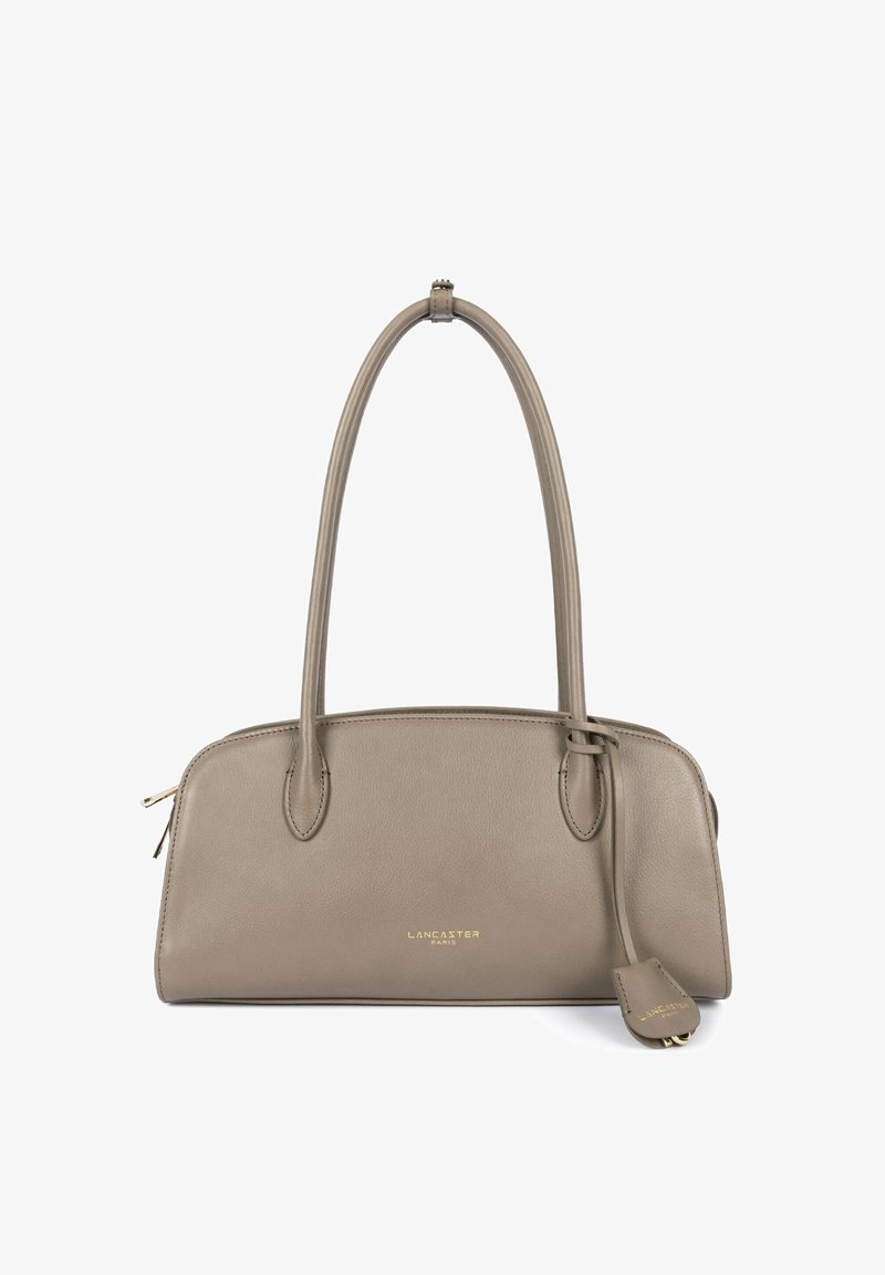 Sac à main Lancaster Paris en cuir taupe avec deux poignées supérieures et une petite étiquette en cuir attachée.